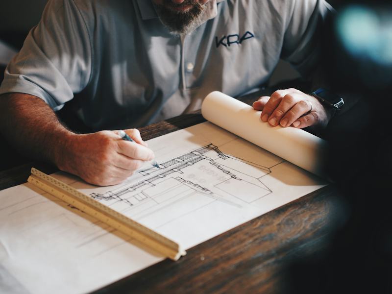 Professionnel annotant des plans de chantier